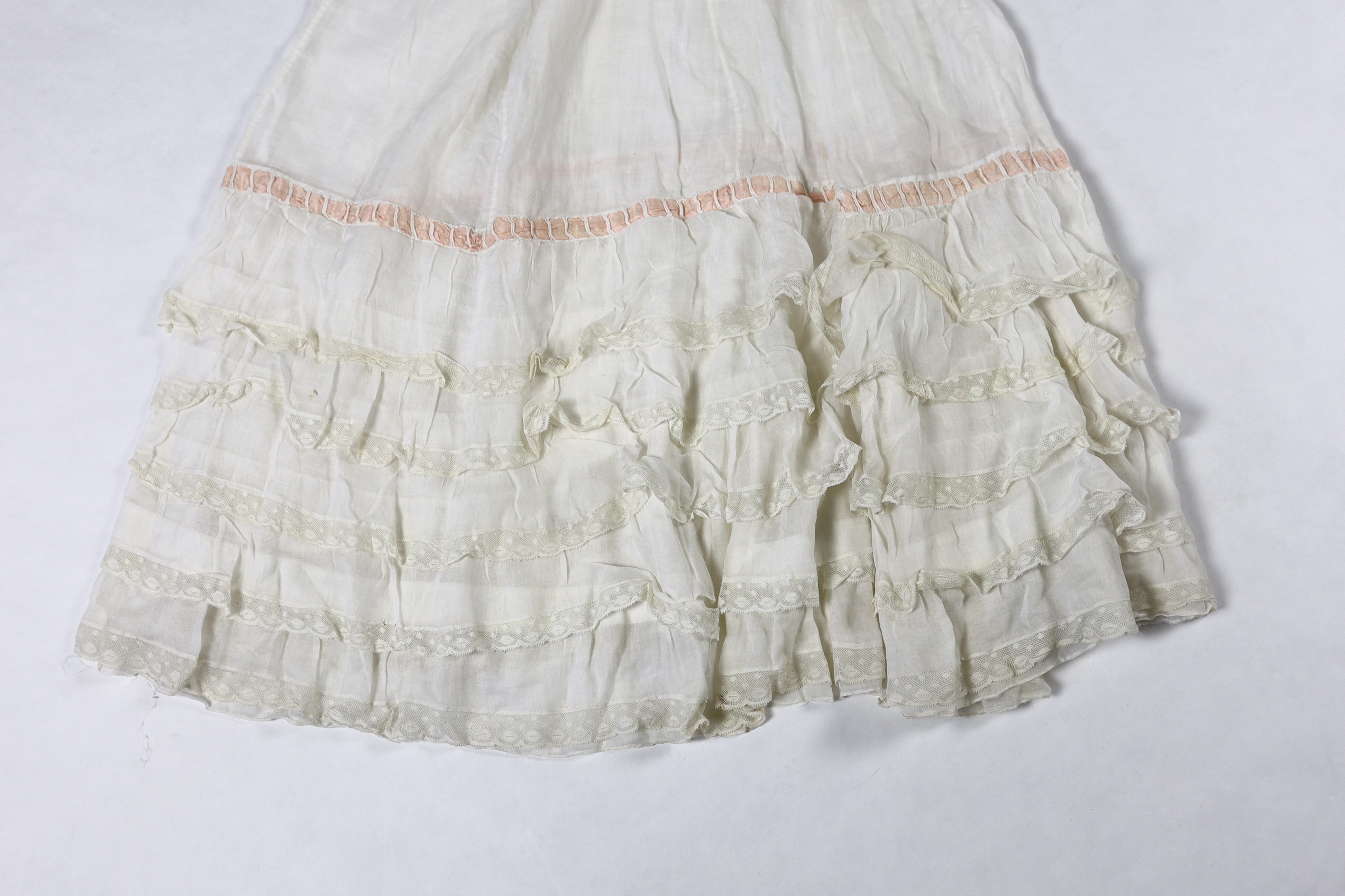 Three Victorian white worked petticoats; one two tiered, one lace trimmed with ribboning, the third worked with cutwork border, all approx. 94cm long
